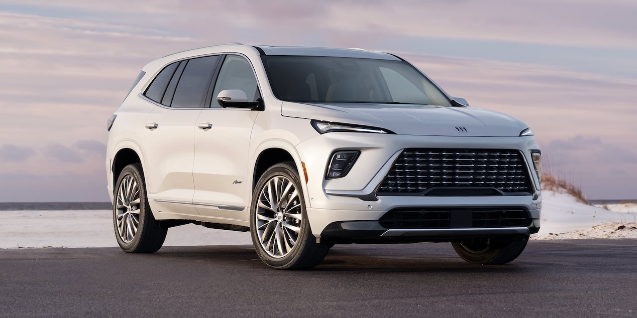 Three-Quarters View of a White 2025 Buick Enclave Parked under Evening Sky
