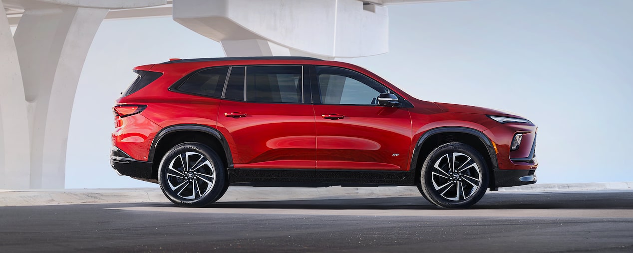 Side View of a Red 2025 Buick Enclave ST Under a Bridge