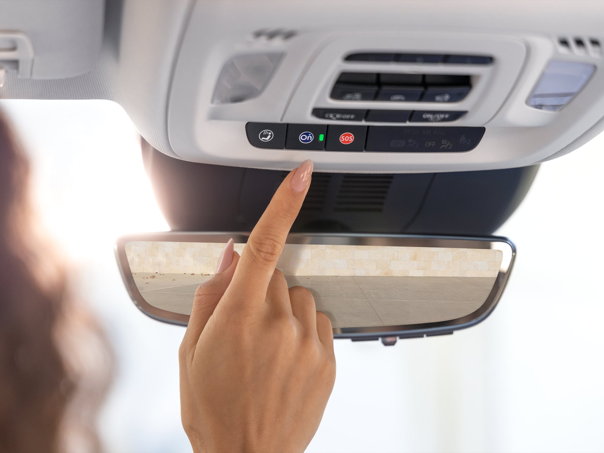 A Woman Pressing the OnStar Button in Her 2026 Buick Encore SUV