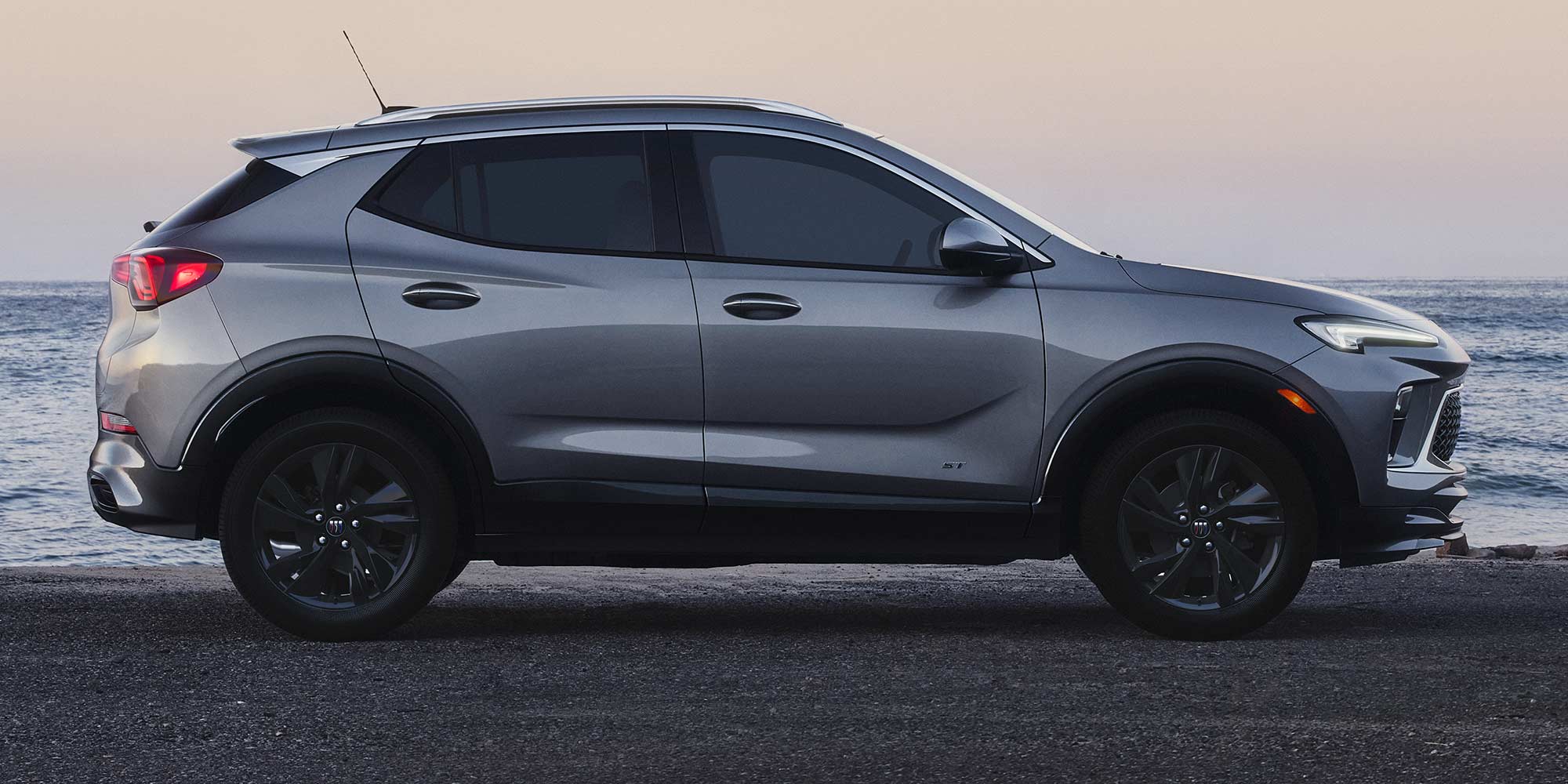 Profile View of the 2026 Buick Encore GX ST Luxury SUV Parked on the Beach at Sunset