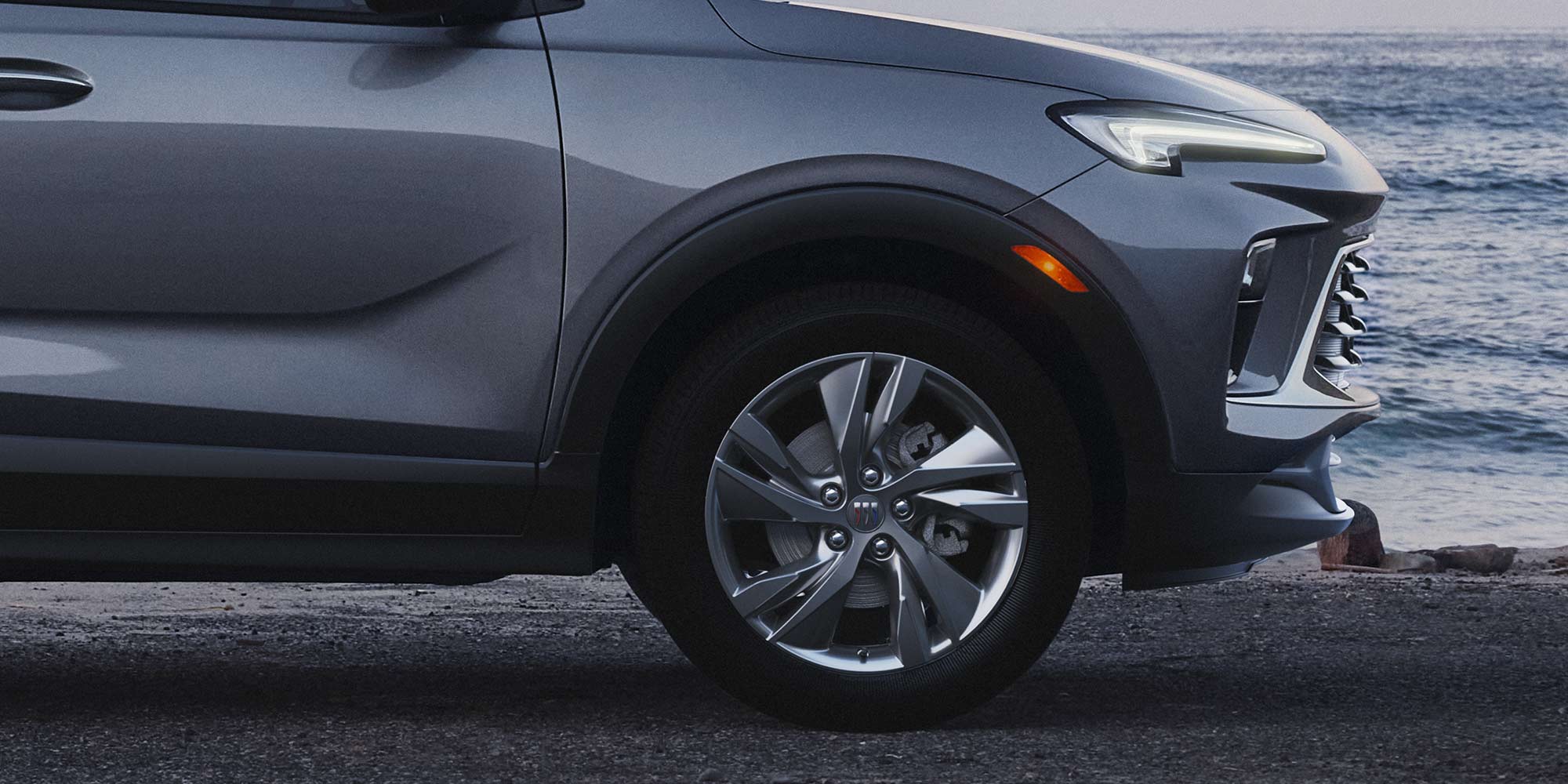 Close-up Profile View of the 2026 Buick Encore GX Avenir Luxury SUV Parked on the Beach at Sunset