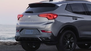 Rear Three-Quarters View of the 2026 Buick Encore GX Avenir Luxury SUV Parked on the Beach at Sunset