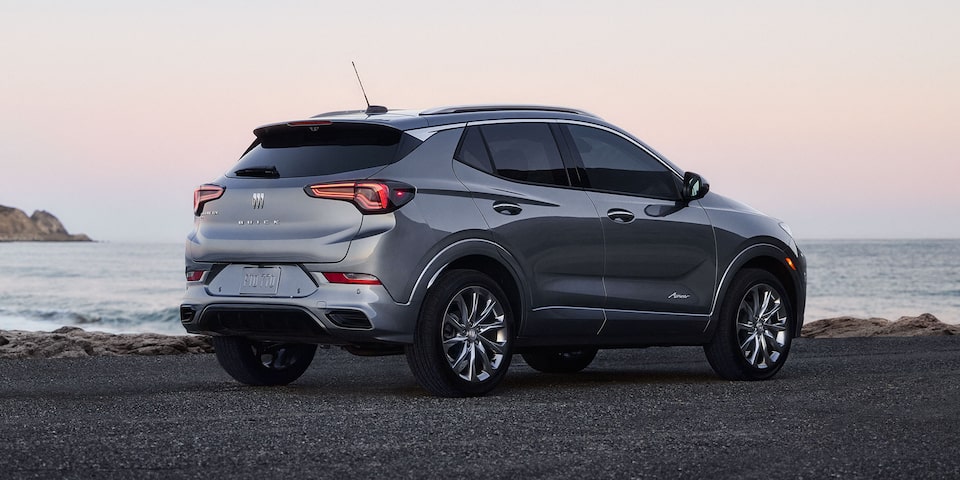 Rear Three-Quarters View of the 2026 Buick Encore GX Avenir Luxury SUV Parked on the Beach at Sunset