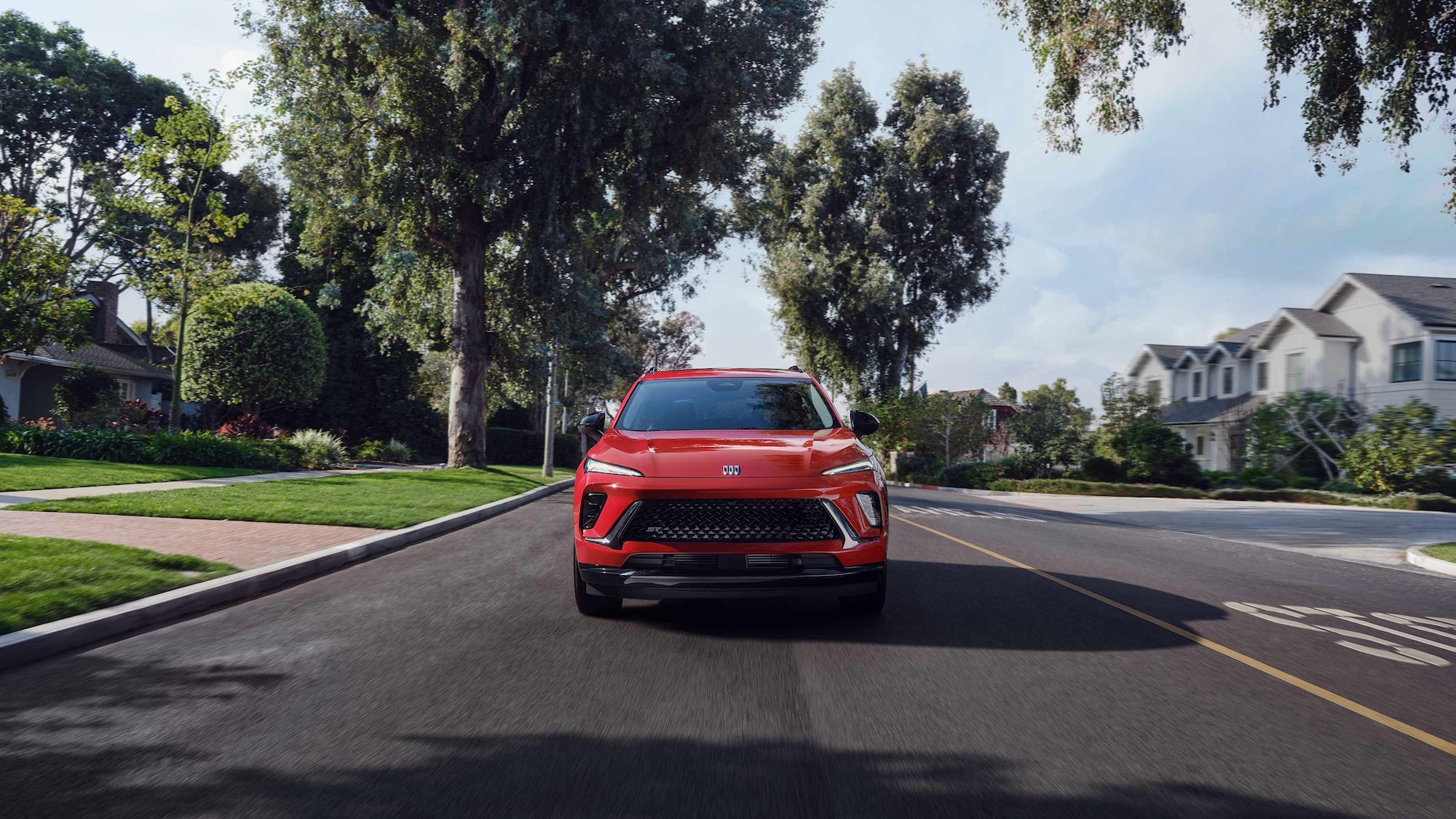 Front View of the 2026 Buick Envision Compact SUV Driving Down a Black Top Road