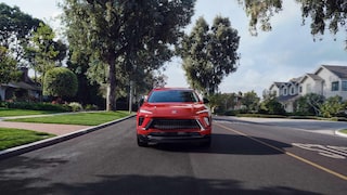 Front View of the 2026 Buick Envision Compact SUV Driving Down a Black Top Road