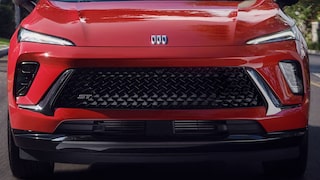 Front View of the 2026 Buick Envision ST Sporty Compact SUV Driving Down a Black Top Road