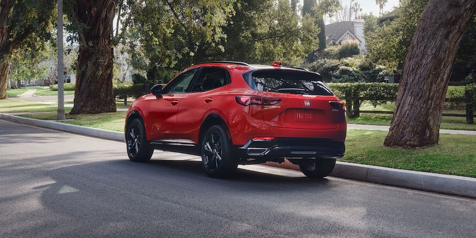 Rear View of the 2026 Buick Envision Compact SUV Driving Through a Neighborhood