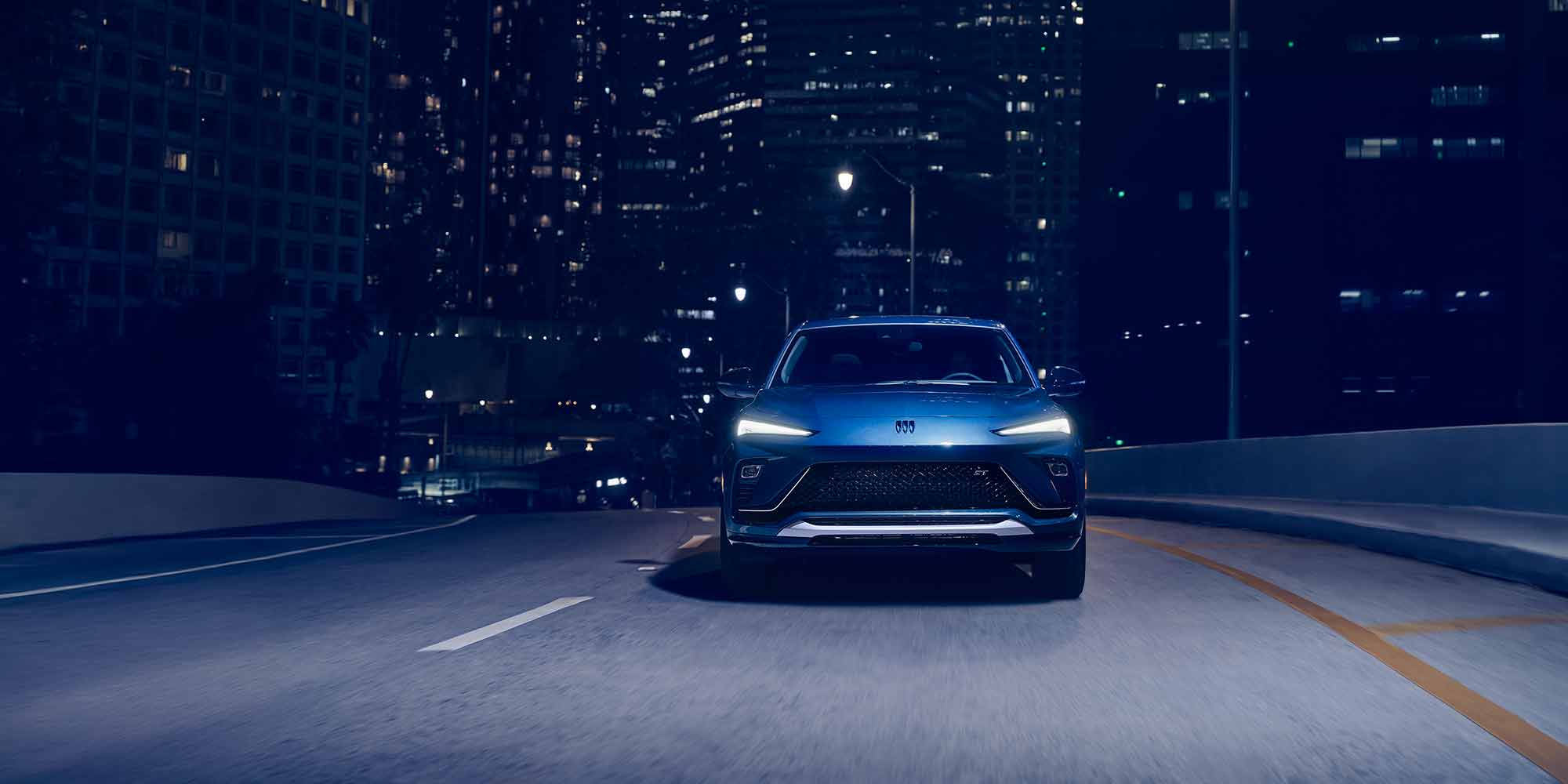 The 2026 Buick Envista Sport Touring Driving Out of the City Under a Street Light