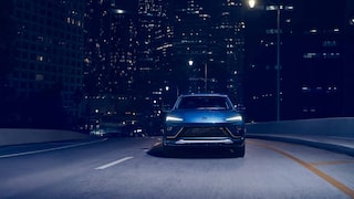 The 2026 Buick Envista Sport Touring Driving Out of the City Under a Street Light