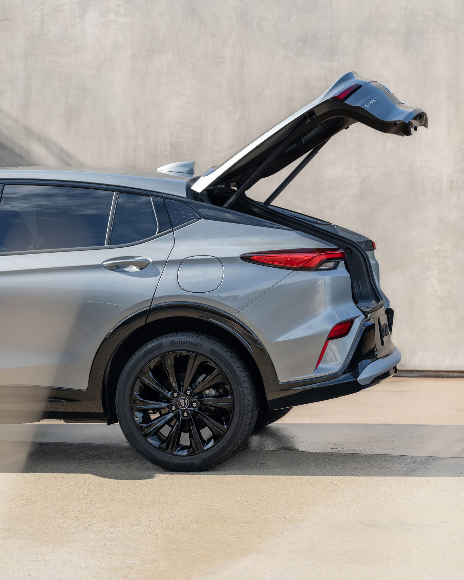 A Man with Luggage Walking to the 2026 Buick Envista and Utilizing the Power Liftgate Feature
