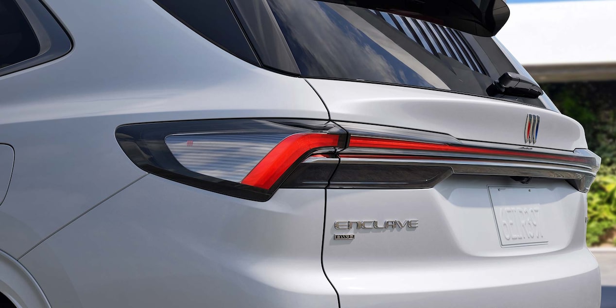 A Close-Up of the Rear Taillight and Enclave Badge on a White Buick SUV