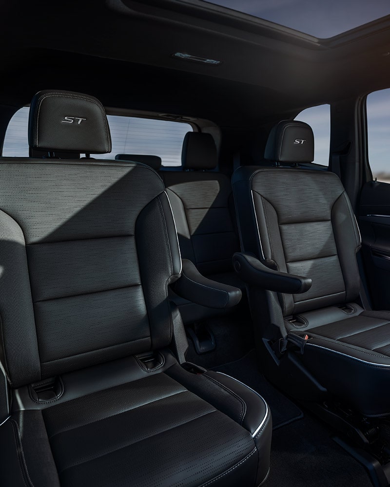 The Interior of a Car Showing Dark Gray Leather Bucket Seats in the Second Row with an ST Logo