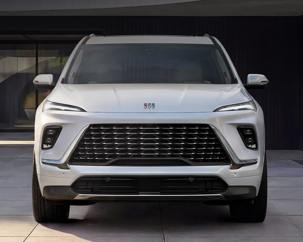 A Front View of a White Buick Enclave SUV Parked Outside a Modern Building