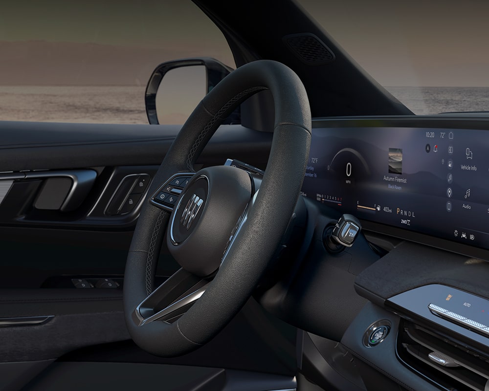 An Interior Shot of a Buick Enclave with the Steering Wheel and a Wide Digital Display