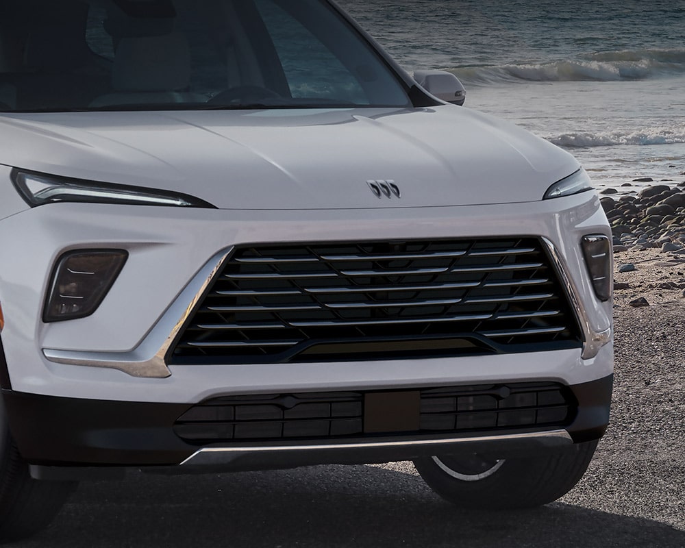 Front Lower Section of a White Buick Enclave with the Grille and Headlights Visible