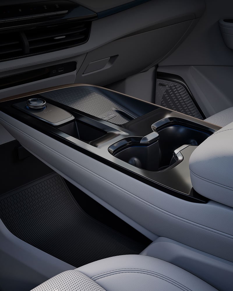 A Close-up of a Car's Center Console and Dashboard Area with a Gear Selector Dial and Cup Holders