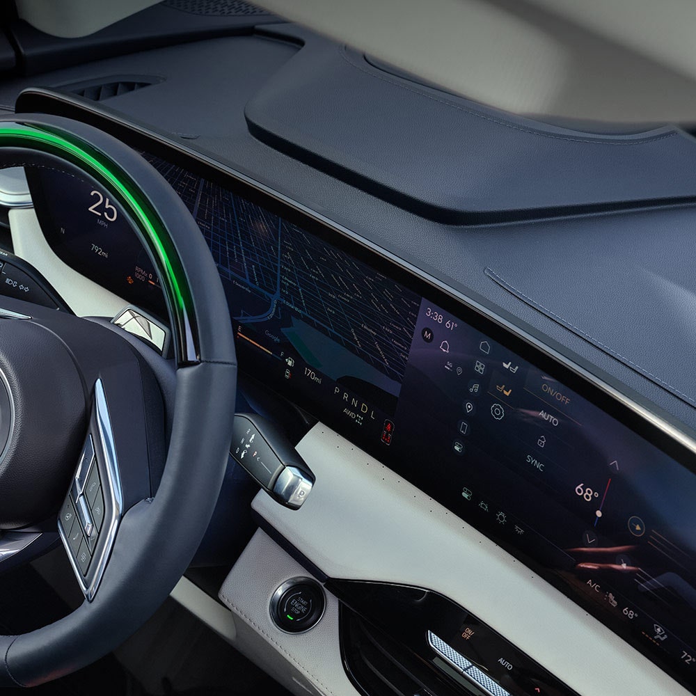 A Driver's Hand Resting on their Lap with a View of the Buick Steering Wheel and Car Door Panel