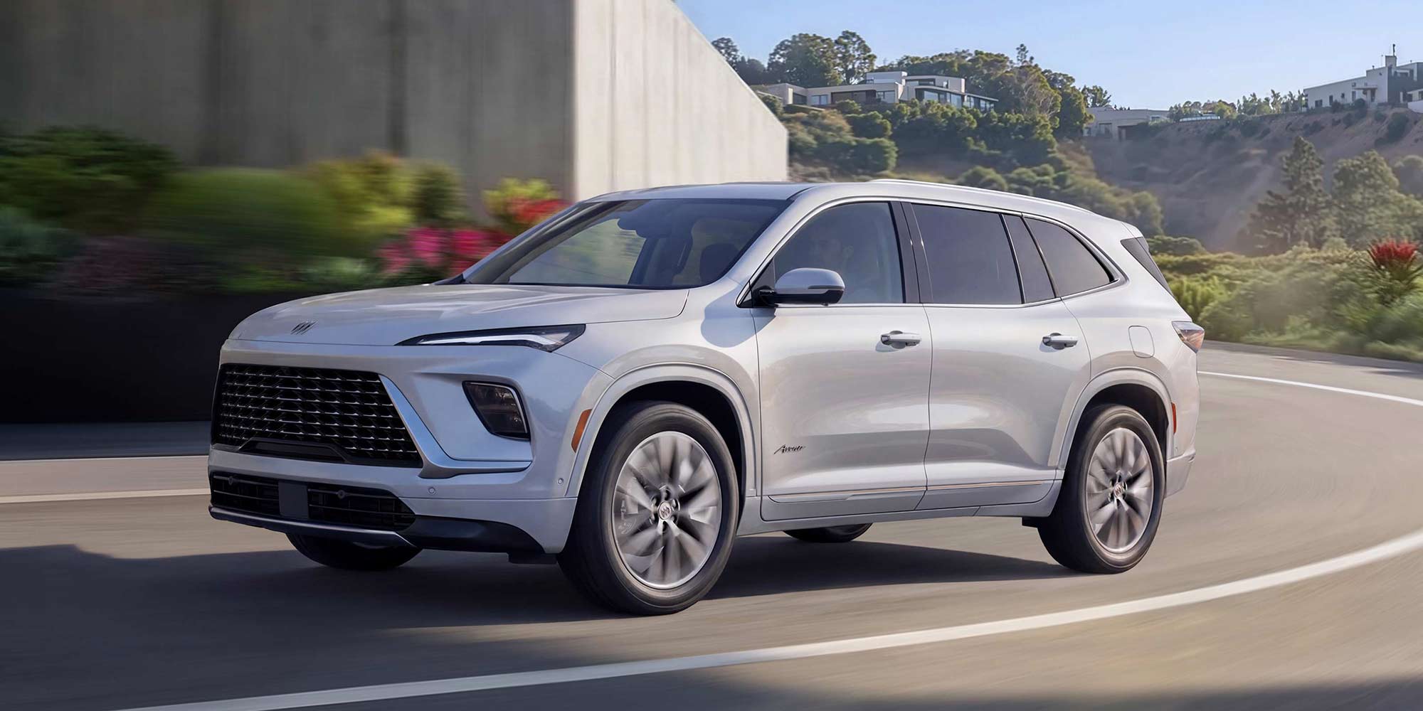 A White Buick Enclave Avenir SUV Driving on a Curved Road