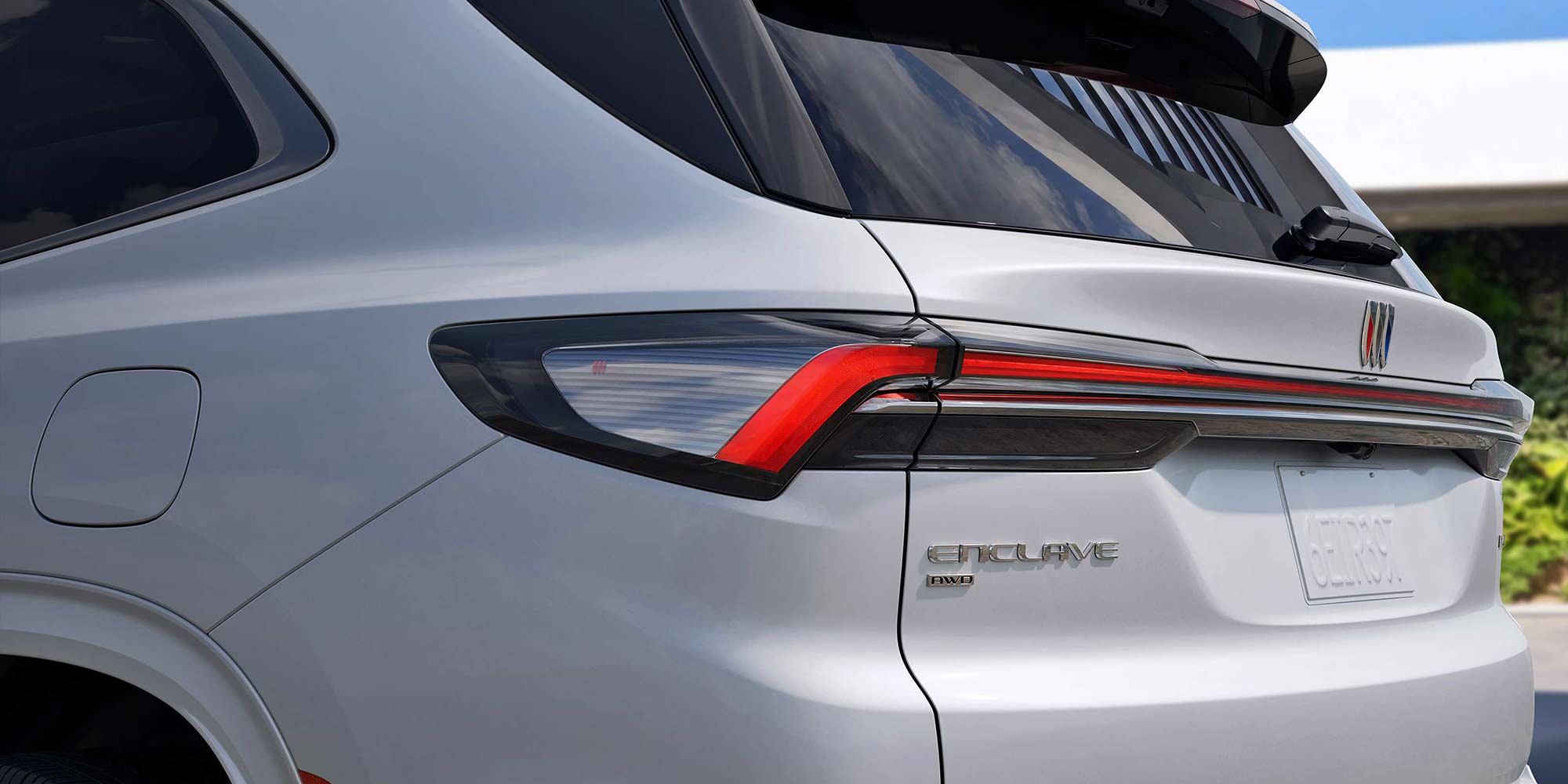 A Close-Up of the Rear Taillight and Enclave Badge on a White Buick Enclave SUV