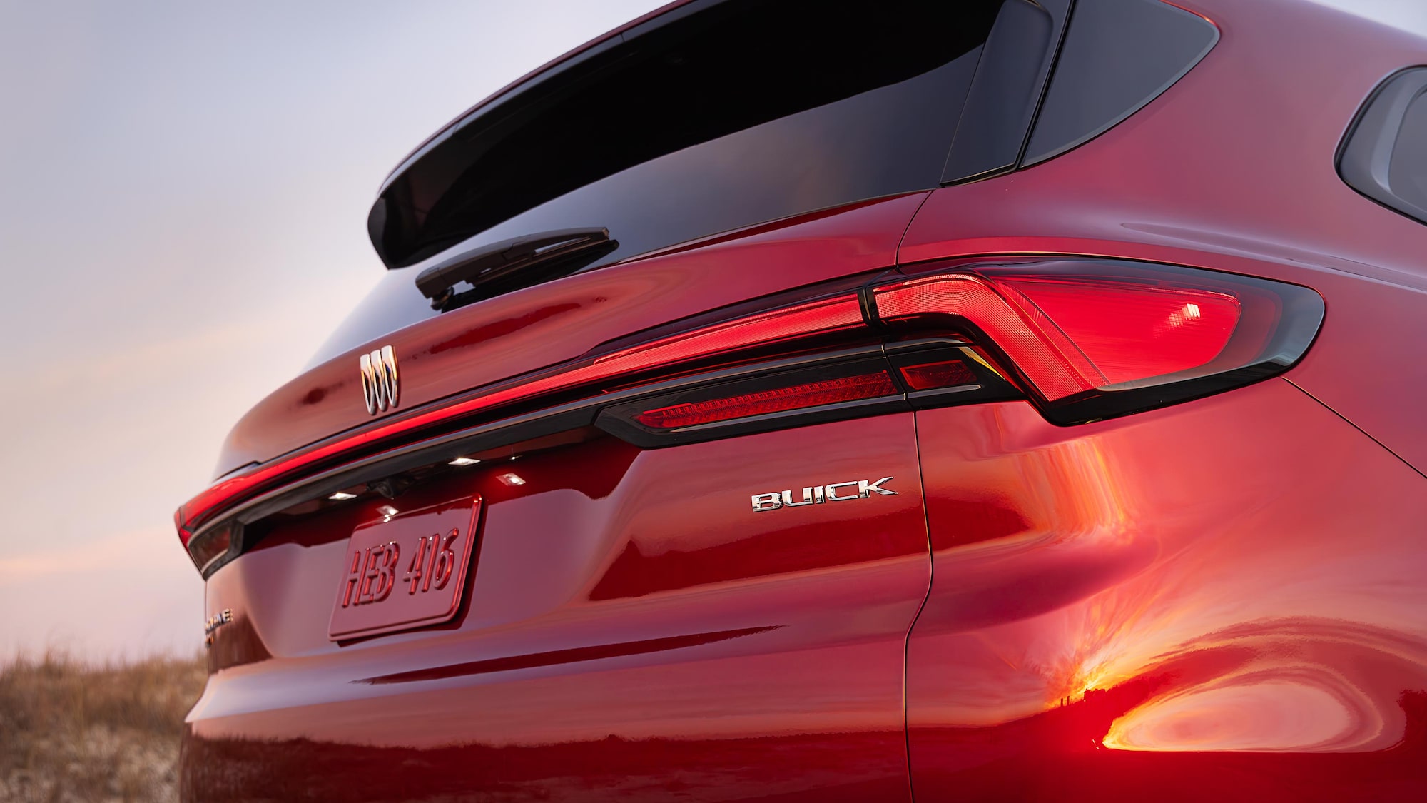 The Rear View of a Red Buick Enclave SUV with a Buick Logo and License Plate Displayed