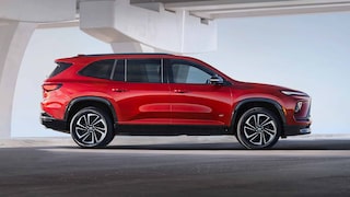 A Red Buick Enclave SUV Parked in Profile under a Modern Architectural Archway