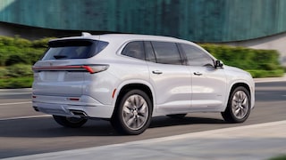 The Rear Angle of a White Buick Enclave Avenir SUV Driving on a Road