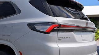 A Close-Up of the Rear Taillight and Enclave Badge on a White Buick Enclave SUV