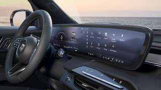 A Close-Up View of the Buick Enclave Dashboard with a Large Curved Digital Display and an Ocean Horizon in the Background