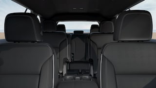 A Buick Enclave Interior with Three Rows of Black Leather Seats and a View to the Ocean