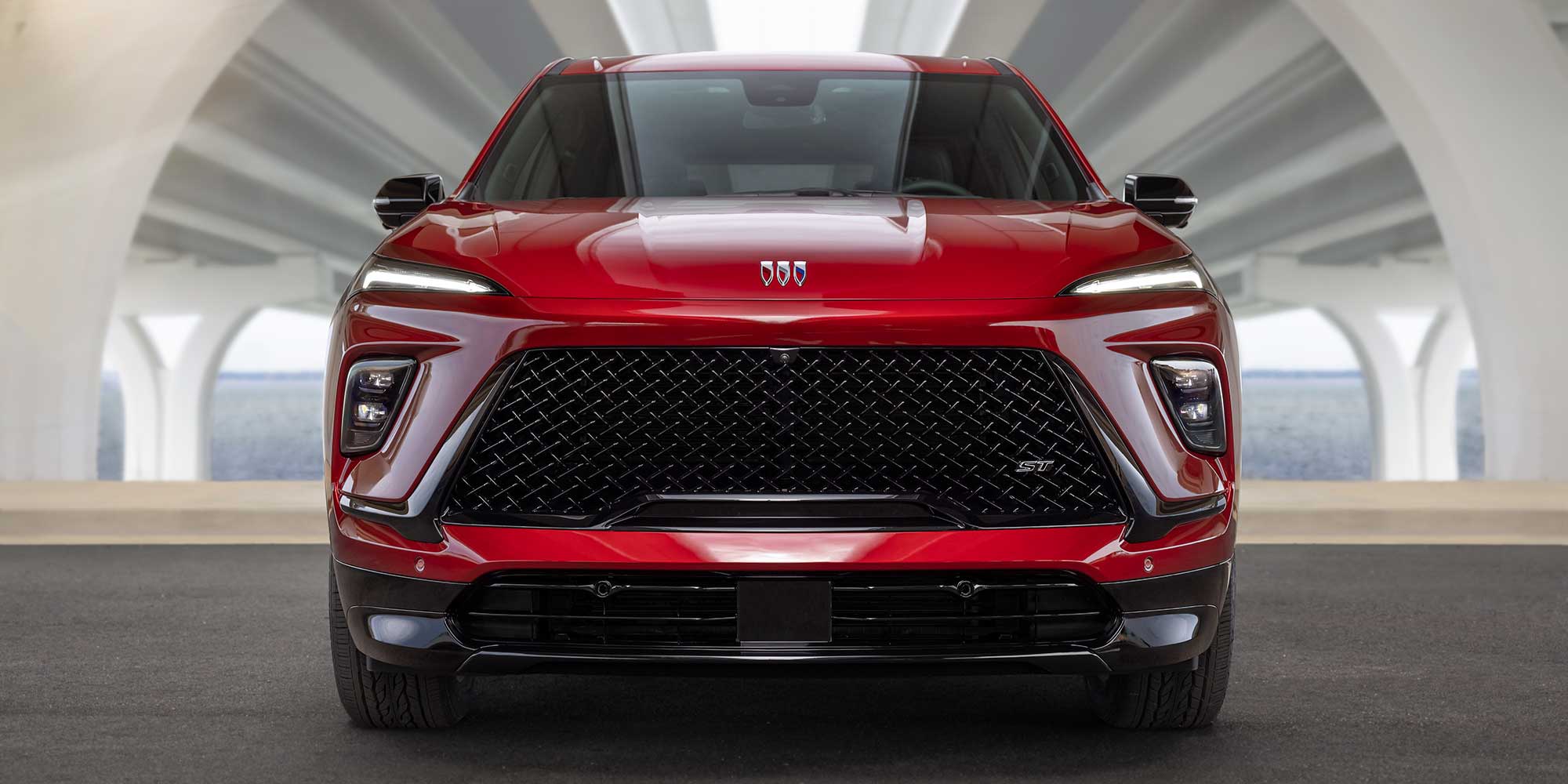 A Front View of a Red Buick SUV Featuring a Large Black Grille and Sleek LED Headlights