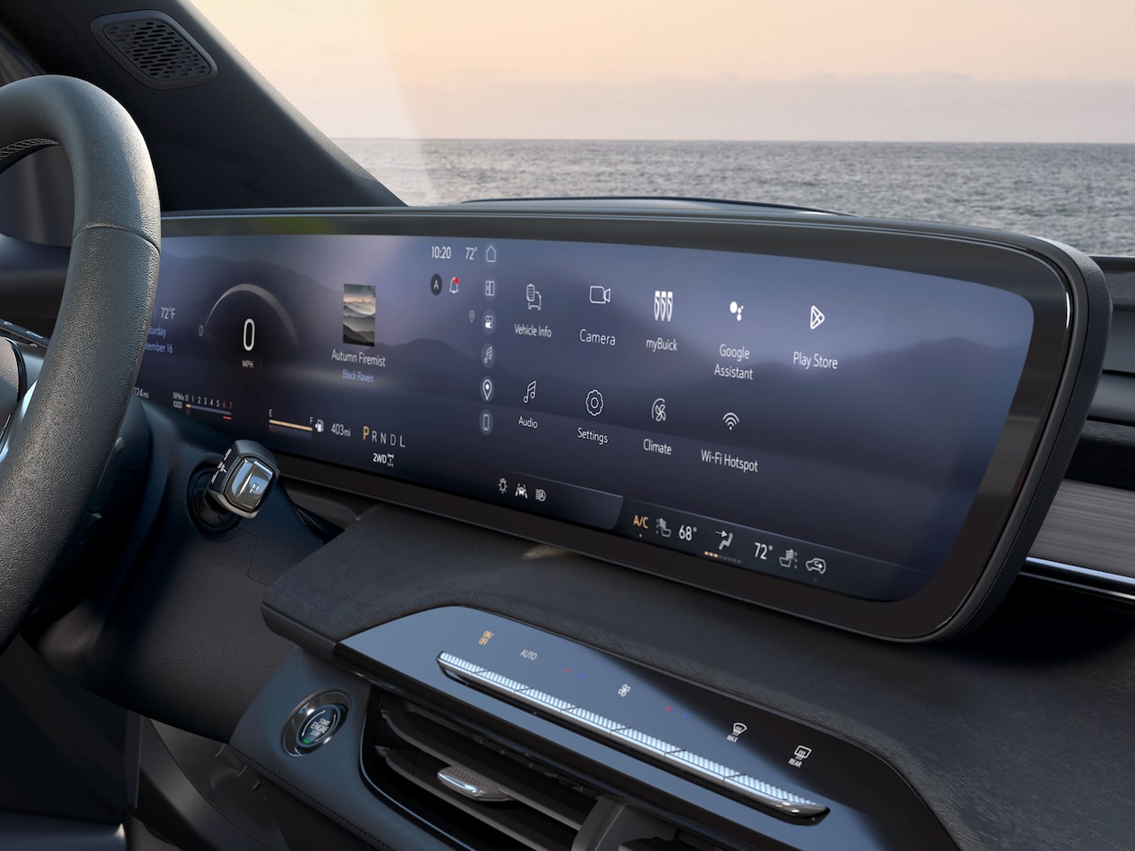 The Interior of a Buick Enclave with a Steering Wheel, a Wide Digital Infotainment Screen, and the Ocean Outside