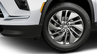 The Front Wheel of a White Buick Enclave with a Multi-Spoke Silver Alloy Rim and Black Tire