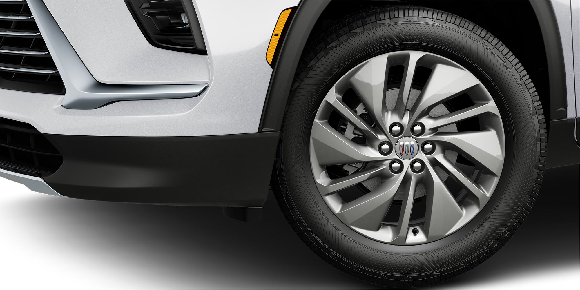 The Front Wheel of a White Buick Enclave with a Multi-Spoke Silver Alloy Rim and Black Tire