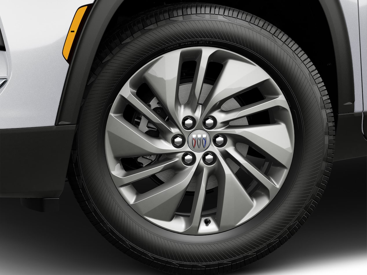The Front Wheel of a White Buick Enclave with a Multi-Spoke Silver Alloy Rim and Black Tire