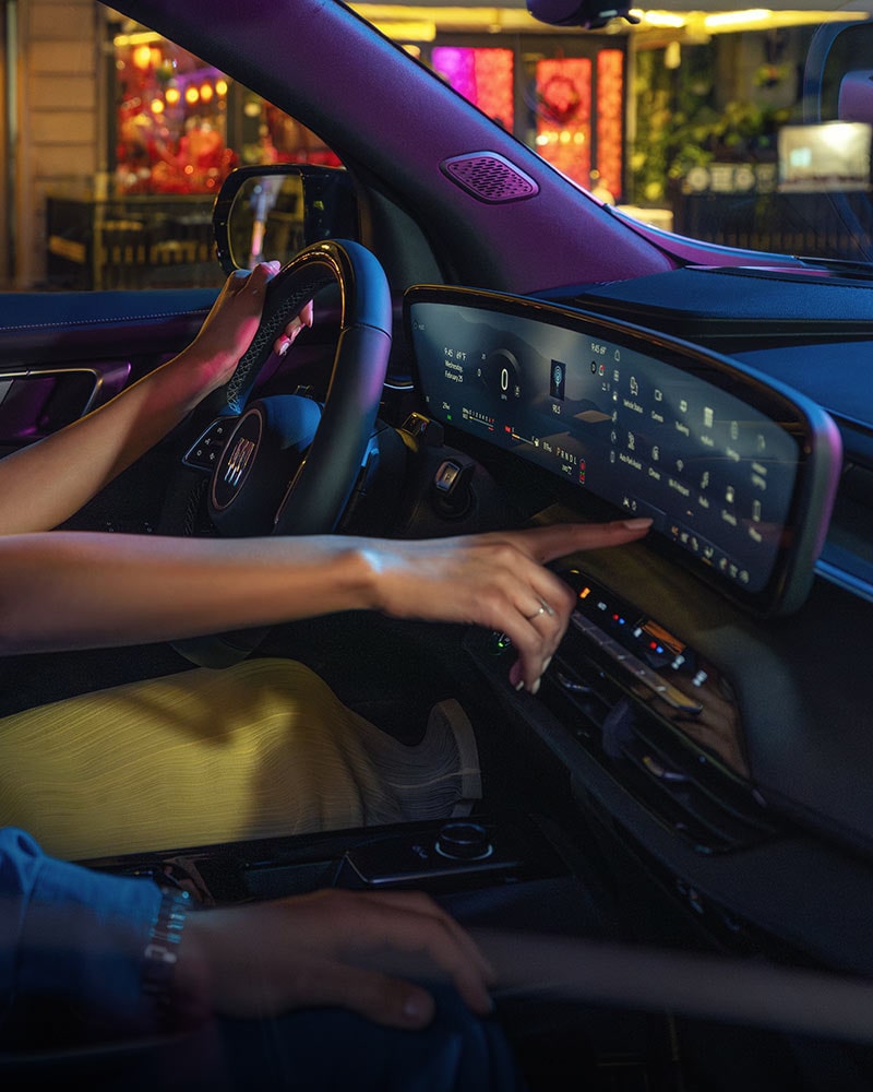 The Driver's Perspective in a Buick SUV with Hands on the Steering Wheel and Digital Screens Displaying Navigation on a Beach