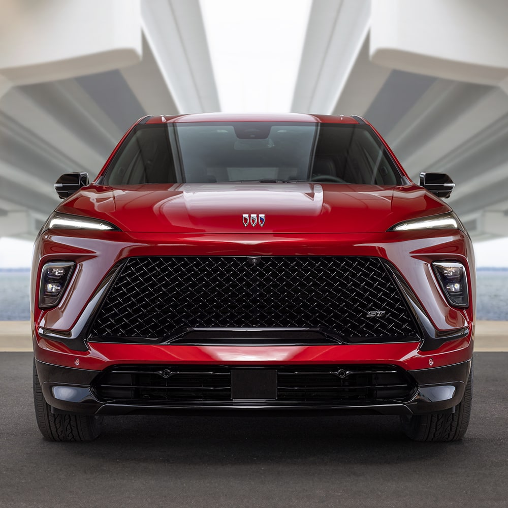 A Front View of a Red Buick SUV Featuring a Large Black Grille and Sleek LED Headlights