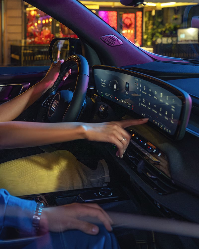 The Driver's Perspective in a Buick SUV with Hands on the Steering Wheel and Digital Screens Displaying Navigation on a Beach
