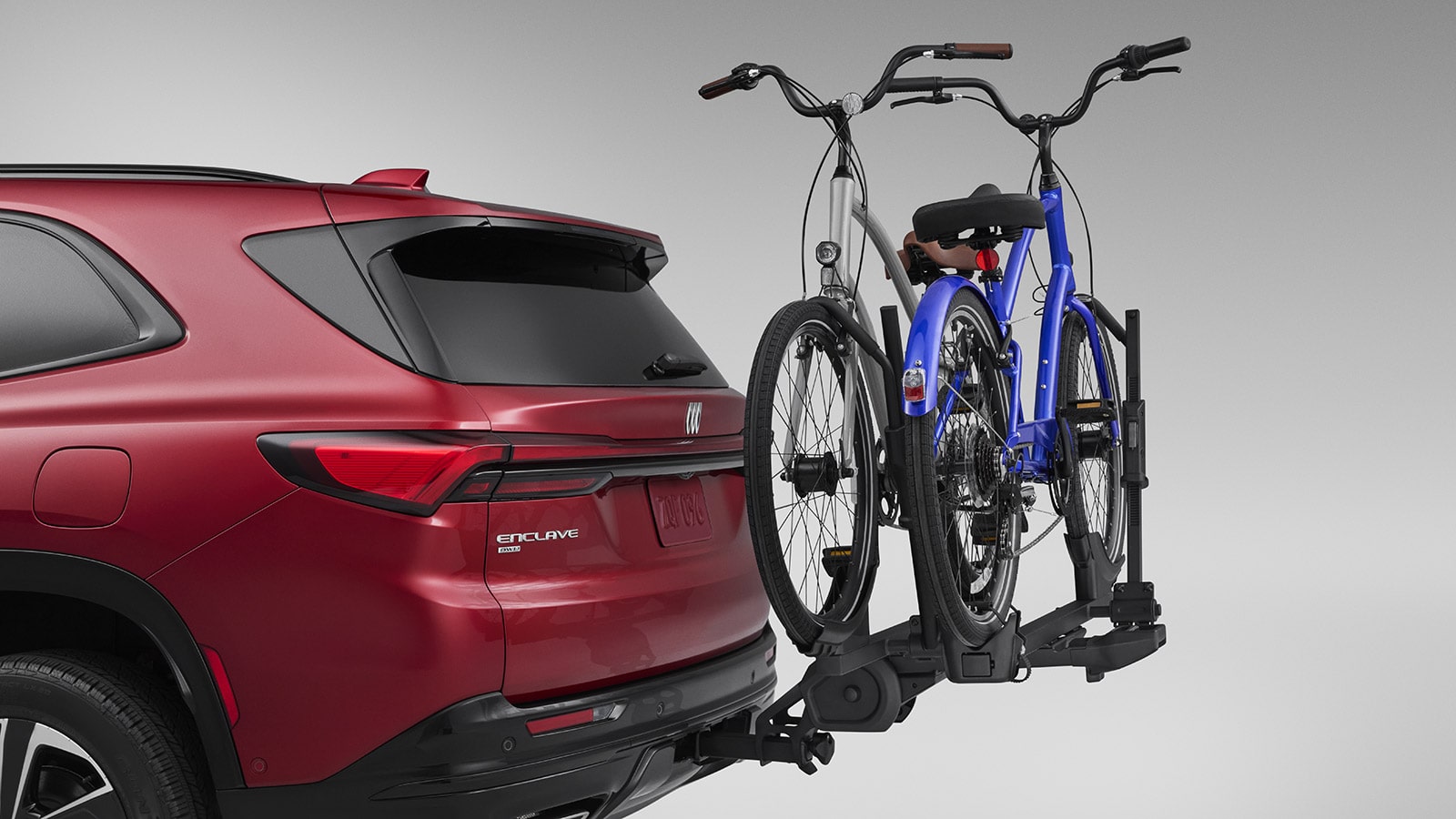 A Red Buick Enclave SUV with a Bike Rack Carrying Two Bicycles on the Rear