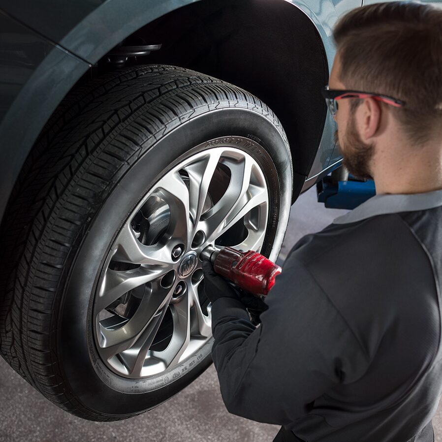 A Buick Technician Tightens the Lug Nuts of a Buick SUV