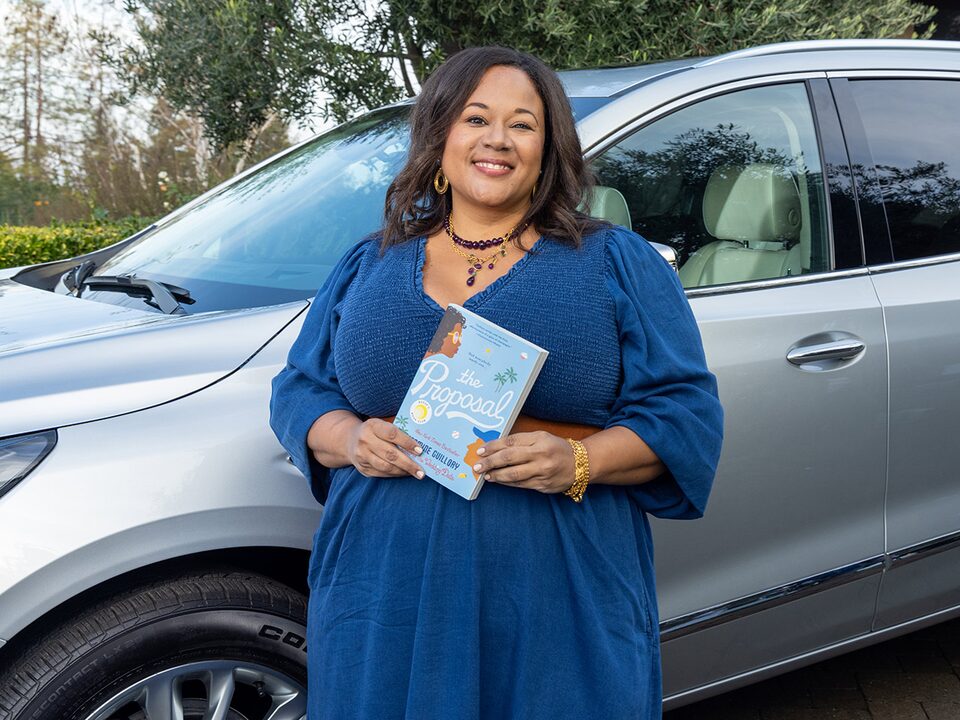 Author Jasmine Guillory Holding Her Book by Buick Enclave